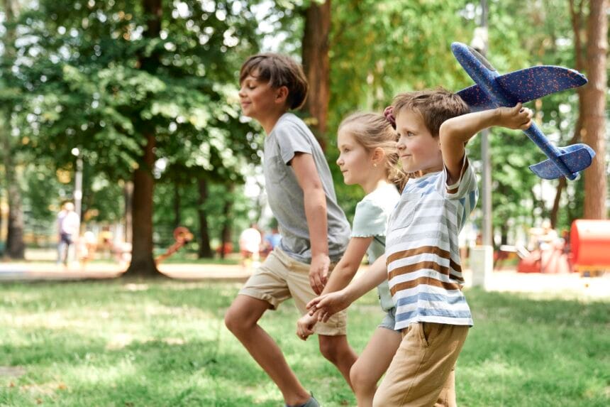 Group of kids playing together with airplane toy Activități distractive pentru dezvoltarea atenției la copiii cu vârste cuprinse între 4 și 6 ani