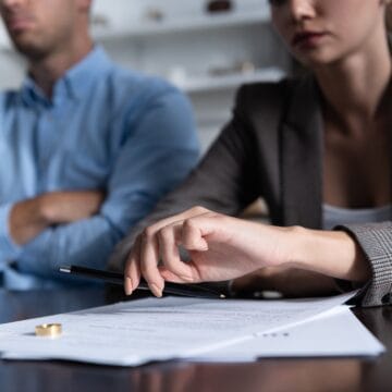 partial view of couple at table with divorce documents Divorț amiabil vs. divorț în instanță: Care este cea mai bună opțiune?