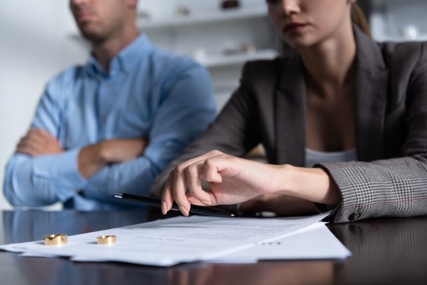 partial view of couple at table with divorce documents Divorț amiabil vs. divorț în instanță: Care este cea mai bună opțiune?