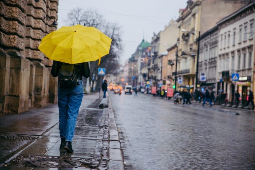Persoană cu umbrelă pe o stradă udă, în timpul ploilor aduse de codul galben din octombrie 2026 Persoană cu umbrelă pe o stradă udă, în timpul ploilor aduse de codul galben din octombrie 2026