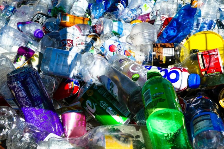 returnare-ambalaje-sgr Grămadă de sticle PET și doze de băuturi pregătite pentru returnare și reciclare